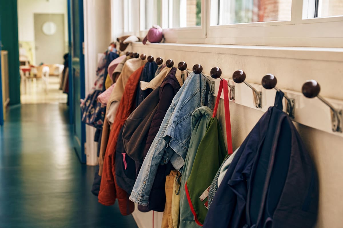 Porte-manteaux serrés dans un couloir d'école, contexte d'une épidémie de poux en classe
